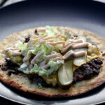 Opskrift på "Tortilla-Burger" med salat, syltede agurker og ost